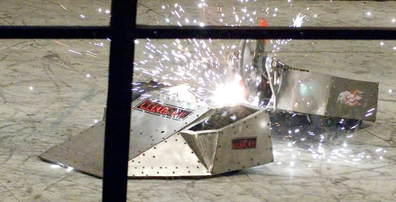 Dos robots de metal chocan en RoboGames 2008 y saltan chispas delante de la jaula