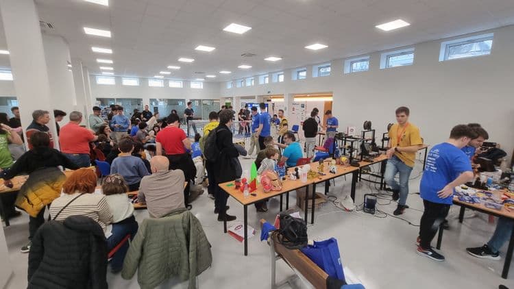 Sala de Robolid con equipos alrededor de las mesas y robots sobre el suelo