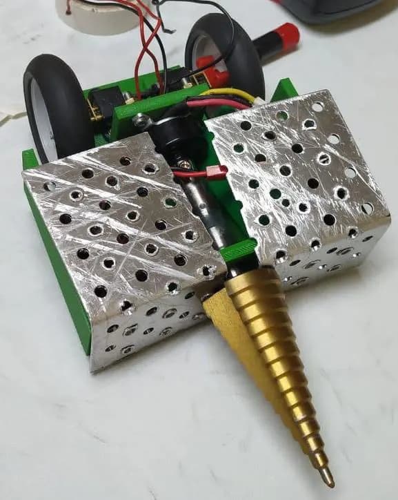 Socavabot con chasis verde impreso, planchas de aluminio perforadas y un arma cónica dorada