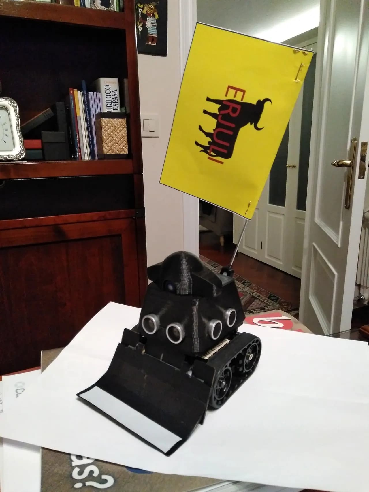 Minisumo negro Erjuli, con cuña delantera, sensores redondos y un capote amarillo